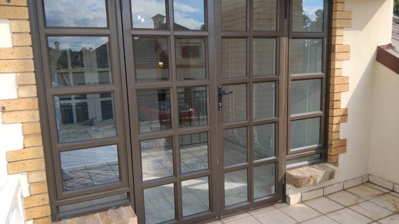 Custom hinge door with side-opening windows in Centurion