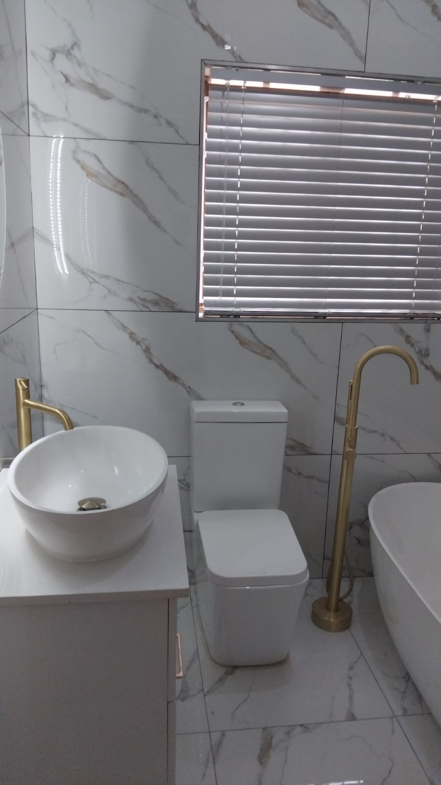 Marble bathroom with gold finishes in Garsfontein