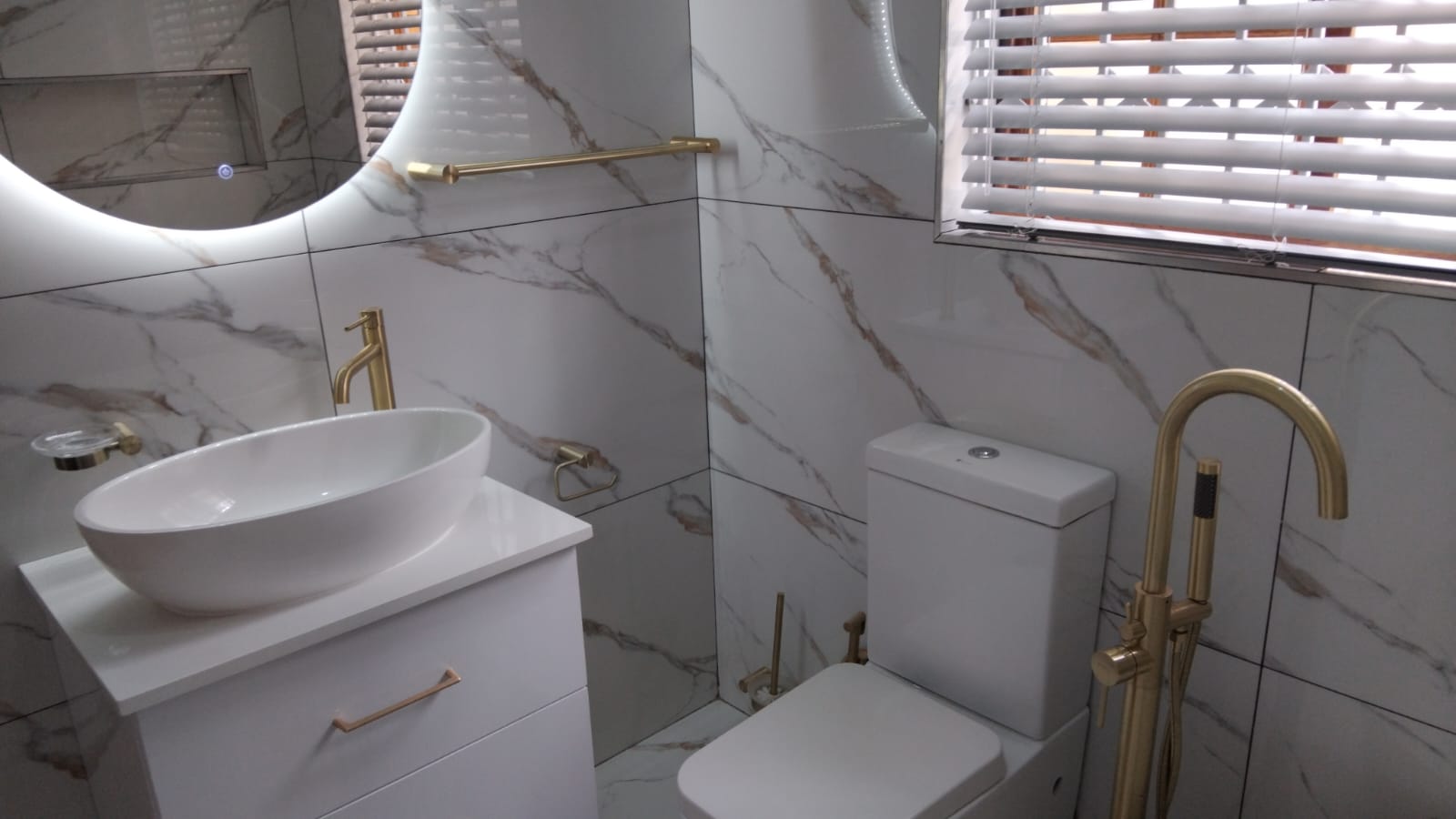 Bright marble bathroom with gold finishes
